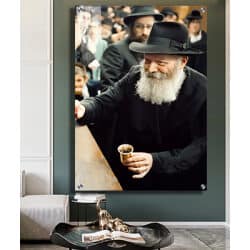 712 – תמונה של הרבי מליובאוויטש מחייך ומחזיק כוס ברכה בהתוועדות